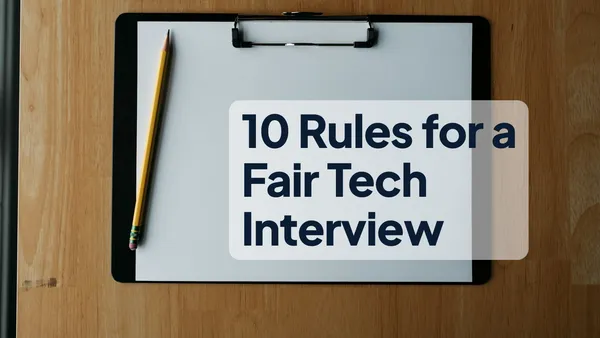 A clipboard with blank paper and a pencil on a wooden desk, with the headline "10 Rules for a Fair Tech Interview" on the paper
