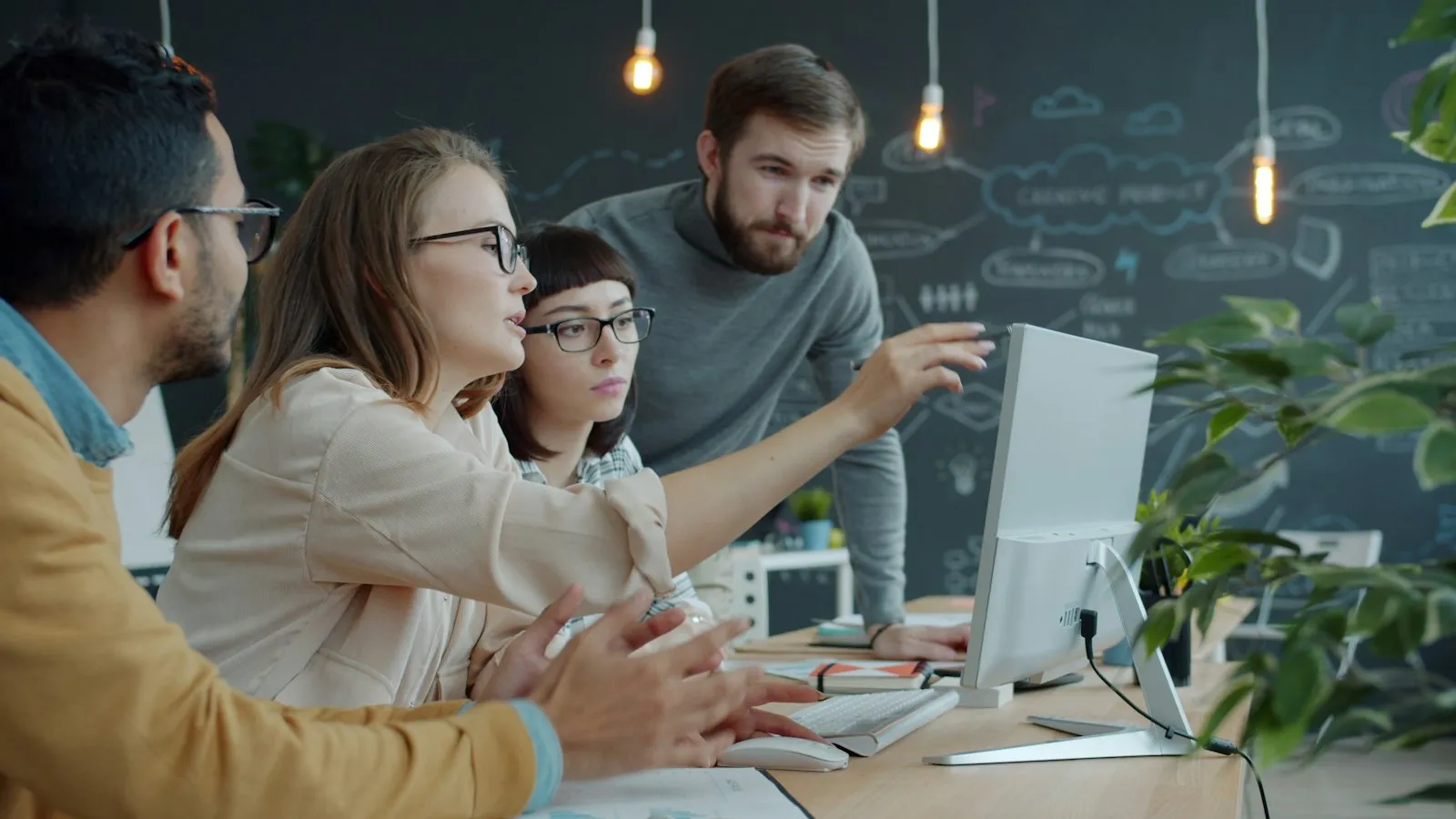 A team collaborating around a computer in an office