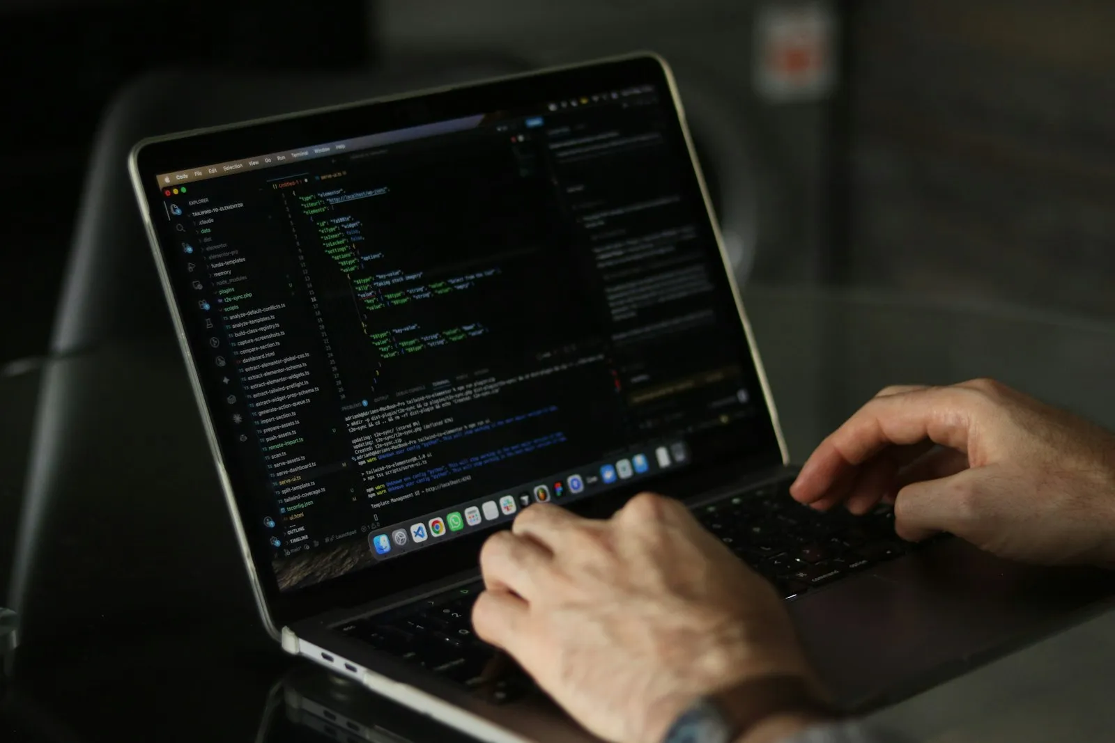 Hands typing code on a laptop keyboard